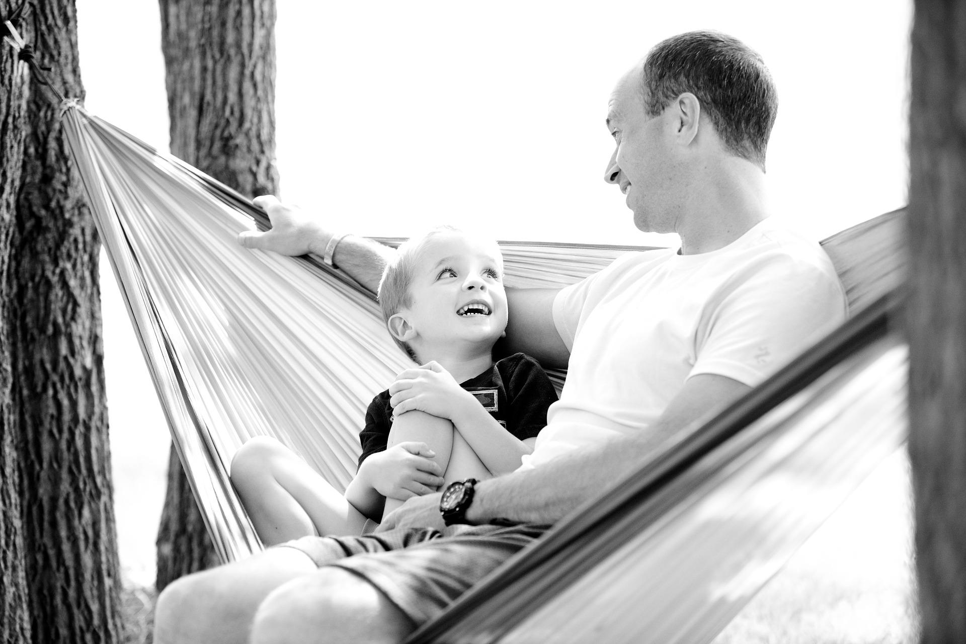 dad sitting in hammock with his son